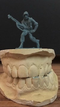 a model of a man with a guitar on top of a tooth