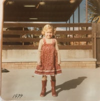 a little girl wearing a dress and boots