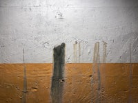 an orange and white wall with paint on it