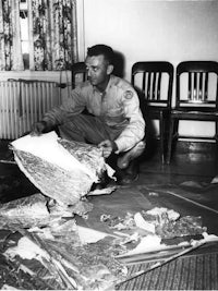 a man sitting on the floor with a piece of paper