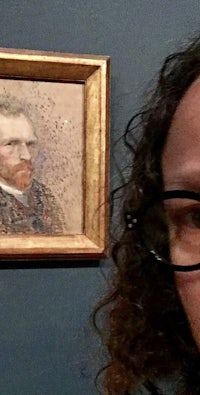 a woman with glasses is taking a selfie in front of a painting