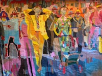 a group of people standing in front of a colorful painting