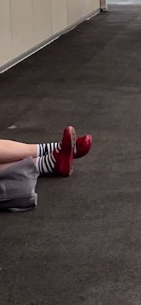 a woman laying on the ground with red shoes