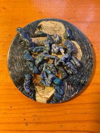 a plate of blue and white flowers on a wooden table