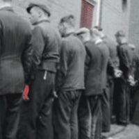 a group of men standing next to a brick wall