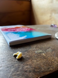 a book on a wooden table next to a glass of water