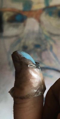 a person's finger with blue paint on it