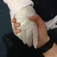 a person holding a person's hand in a white glove