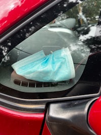 a medical mask in the window of a car