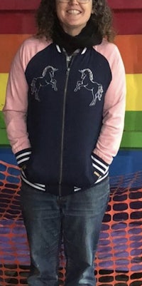 a woman wearing a jacket with a unicorn on it