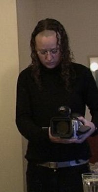 a woman holding a camera in front of a mirror