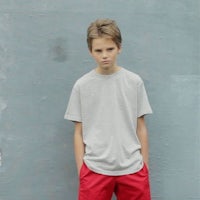 a young boy wearing a grey t - shirt and red shorts