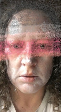 a photo of a woman with pink paint on her face