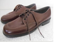 a pair of brown oxford shoes on a white surface