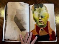 an open book with an image of a man's face