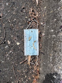 a blue face mask lying on the ground