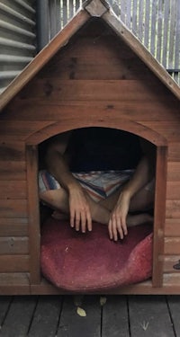 a man sitting inside a dog house