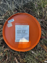 an orange plate with a label on it laying on the ground