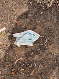 a blue face mask laying on the ground