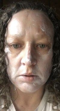 a woman with a white face mask on her face