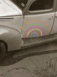 an old car with a rainbow painted on it