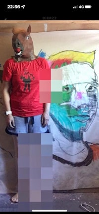 a person in a red shirt is standing next to a painting