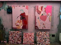 three paintings on a pink wall in an art studio